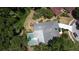 Aerial shot of the home featuring a private pool with screened enclosure and lush surrounding greenery at 5701 Ainsworth W Ct, Tampa, FL 33647