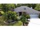 Charming home featuring a well-manicured lawn and a lush array of tropical landscaping in the front yard at 5701 Ainsworth W Ct, Tampa, FL 33647