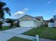 Exterior side view of home with well-manicured lawn and landscaping, and two-car garage at 1210 Etchfield Cir, Brandon, FL 33511