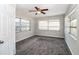 This bedroom features neutral paint and carpet, a ceiling fan, and natural light from the windows at 1453 Thames Ln, Clearwater, FL 33755
