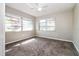 This bedroom has neutral paint and carpet, a ceiling fan, and natural light from the windows at 1453 Thames Ln, Clearwater, FL 33755