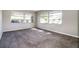 This bedroom has neutral paint and carpet and lots of natural light from the large windows at 1453 Thames Ln, Clearwater, FL 33755