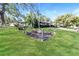Charming single-story home with a well-manicured lawn and mature trees on a sunny day at 1453 Thames Ln, Clearwater, FL 33755