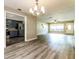 Open-concept living space with modern lighting, laminate flooring and an open flow to kitchen at 1453 Thames Ln, Clearwater, FL 33755
