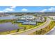 Scenic aerial view of community amenities including tennis courts, clubhouse, and a pool by a lake at 10735 Spring Tide Way, Parrish, FL 34219
