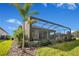 Exterior view of the home showcasing the screened pool area and landscaped backyard at 10735 Spring Tide Way, Parrish, FL 34219