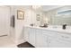 Bathroom featuring double sinks, white cabinets, modern fixtures, and ample counter space at 10735 Spring Tide Way, Parrish, FL 34219