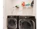 Laundry room featuring modern washer and dryer units with overhead shelving at 10735 Spring Tide Way, Parrish, FL 34219