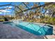 Sparkling pool with a screened enclosure and lush landscaping, ideal for enjoying the outdoors at 10735 Spring Tide Way, Parrish, FL 34219