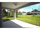 Covered patio overlooking a large, well-maintained backyard with mature trees and lush greenery at 3092 Crowder St, Port Charlotte, FL 33980