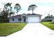 Charming single-story home featuring a well-manicured lawn and a two-car garage at 3092 Crowder St, Port Charlotte, FL 33980