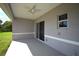A covered patio with a ceiling fan and sliding glass doors overlooks a grass lawn at 3092 Crowder St, Port Charlotte, FL 33980