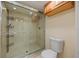 Bathroom featuring a glass-enclosed shower with shelving and a toilet at 14810 Rue De Bayonne # 7B, Clearwater, FL 33762