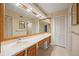 A well-lit bathroom featuring dual sinks, a large mirror, and classic cabinetry at 14810 Rue De Bayonne # 7B, Clearwater, FL 33762