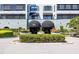 Building entrance featuring dual black awnings and manicured hedges at 14810 Rue De Bayonne # 7B, Clearwater, FL 33762