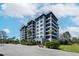 Exterior view of a multi-story building featuring green lawns, landscaping, and palm trees at 14810 Rue De Bayonne # 7B, Clearwater, FL 33762