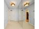 Hallway with mirrored wall and tiled flooring, illuminated by decorative light fixtures at 14810 Rue De Bayonne # 7B, Clearwater, FL 33762