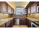 Kitchen with wood cabinets, granite countertops, stainless steel appliances, and a window above the sink at 14810 Rue De Bayonne # 7B, Clearwater, FL 33762