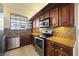 Kitchen featuring wood cabinets, granite countertops, stainless steel appliances, and ample natural light from a window at 14810 Rue De Bayonne # 7B, Clearwater, FL 33762