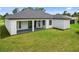 Exterior backyard view with covered patio and lush green lawn at 2805 Anniston Rd, North Port, FL 34288