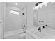 Modern bathroom with white marble tiling, bathtub, and quartz vanity top at 2805 Anniston Rd, North Port, FL 34288