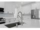 Modern kitchen featuring stainless steel appliances, white cabinets, quartz countertops and a stylish faucet at 2805 Anniston Rd, North Port, FL 34288
