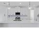Modern kitchen with white cabinets, quartz countertops, stainless steel appliances, and a spacious center island at 2805 Anniston Rd, North Port, FL 34288