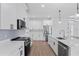 This modern kitchen features white cabinetry, stainless steel appliances, quartz countertops, and a functional design at 2805 Anniston Rd, North Port, FL 34288