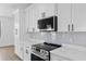 Close up of a kitchen with white cabinets, modern appliances, quartz countertops, and stylish backsplash at 2805 Anniston Rd, North Port, FL 34288