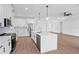 Open-concept kitchen with island, stainless steel appliances, white cabinets and pendant lighting at 2805 Anniston Rd, North Port, FL 34288