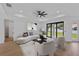 Staged living room featuring a modern ceiling fan and sliding glass doors to the outside at 2805 Anniston Rd, North Port, FL 34288