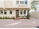 Exterior of townhome with brick paved parking, neutral colored exterior and manicured landscaping at 235 Cocoanut Ave # 129E, Sarasota, FL 34236