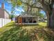 Backyard featuring grassy lawn, mature trees, playground and screen-enclosed patio on house at 4601 Copper Ln, Plant City, FL 33566