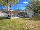 Exterior view of the home with a screened in porch and mature tree in the backyard at 4601 Copper Ln, Plant City, FL 33566