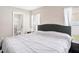 Bright main bedroom featuring a large bed, two windows and adjacent bathroom at 4601 Copper Ln, Plant City, FL 33566