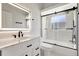 Elegant bathroom featuring a sleek vanity with drawers and an illuminated mirror, plus a walk-in shower and accent tile at 11019 Pine Lilly Pl, Lakewood Ranch, FL 34202
