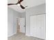 Well-lit bedroom features a ceiling fan, wood-look floors, and a doorway leading to an en-suite bathroom at 11019 Pine Lilly Pl, Lakewood Ranch, FL 34202