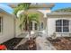 Charming entryway features an oval glass front door, arched entry, and lush tropical landscaping at 11019 Pine Lilly Pl, Lakewood Ranch, FL 34202