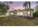 Stunning home with manicured lawn, palm trees, and a neutral color scheme, beautifully lit against a sunset sky at 11019 Pine Lilly Pl, Lakewood Ranch, FL 34202