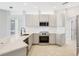 Bright kitchen boasts white cabinets, stainless steel appliances, and a marble countertop island at 11019 Pine Lilly Pl, Lakewood Ranch, FL 34202