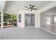 Covered lanai with ceiling fan, sliding glass doors, and a peaceful view of the screened-in pool and backyard at 11019 Pine Lilly Pl, Lakewood Ranch, FL 34202