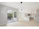 Living room with sliding glass door to the patio and modern light fixture at 11019 Pine Lilly Pl, Lakewood Ranch, FL 34202