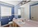 Cozy blue bathroom featuring a sailboat-themed wallpaper, large window and white vanity at 11120 5Th E St, Treasure Island, FL 33706