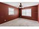 Simple bedroom with red walls, two windows, and overhead fan at 11120 5Th E St, Treasure Island, FL 33706