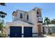 Stunning two-story home with blue accents, arched windows, and a well-manicured lawn at 11120 5Th E St, Treasure Island, FL 33706