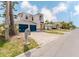 Two-story home with blue garage doors, balconies, dolphin statue, and concrete driveway at 11120 5Th E St, Treasure Island, FL 33706