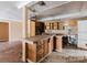 Outdated kitchen features wooden cabinetry, an island with tile countertops, and dated appliances at 11120 5Th E St, Treasure Island, FL 33706
