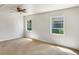 Bright bedroom with neutral carpet, ceiling fan and two windows at 1115 31St W St, Bradenton, FL 34205