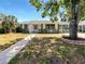 Charming single-story home with a brick walkway, landscaped front yard, and a mature shade tree at 1115 31St W St, Bradenton, FL 34205