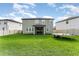 Spacious backyard with lush green lawn, fenced perimeter, and screened porch, ideal for outdoor living and recreation at 13532 Palmera Vista Dr, Riverview, FL 33579